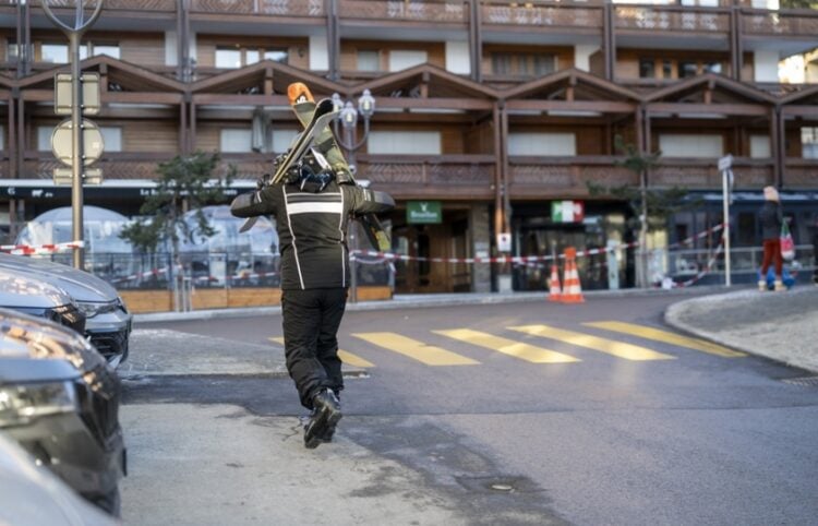 Σκιέρ περπατά κοντά στο μπαρ όπου σημειώθηκε η φονική πυρκαγιά στο Κραν Μοντανά (φωτ.: EPA/Alessandro Della Valle)