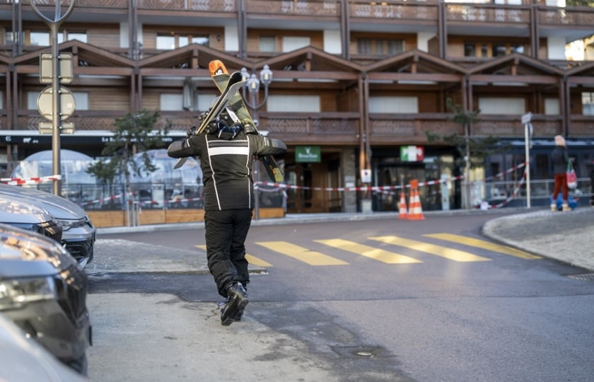 Σκιέρ περπατά κοντά στο μπαρ όπου σημειώθηκε η φονική πυρκαγιά στο Κραν Μοντανά (φωτ.: EPA/Alessandro Della Valle)