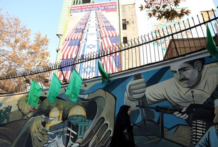 Ιρανή περνάει από την πλατεία Παλαιστίνης στην Τεχεράνη που τις τελευταίες εβδομάδες συγκλονίζεται από σοβαρά επεισόδια ενώ έχουν καταγραφεί δεκάδες νεκροί και τραυματίες (φωτ.: EPA/ ABEDIN TAHERKENAREH)