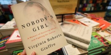 Πελάτης βιβλιοπωλείου κρατά τα απομνημονεύματα της Βιρτζίνια Τζουφρέ, η οποία αυτοκτόνησε την άνοιξη του 2025, αφού είχε κατηγορήσει για χρόνια τον πρώην πρίγκιπα Άντριου και τον Τζέφρι Έπστιν ότι την είχαν κακοποιήσει σεξουαλικά (φωτ.: EPA/Andy Rain)