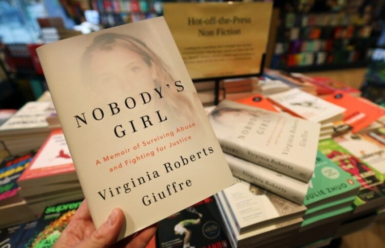 Πελάτης βιβλιοπωλείου κρατά τα απομνημονεύματα της Βιρτζίνια Τζουφρέ, η οποία αυτοκτόνησε την άνοιξη του 2025, αφού είχε κατηγορήσει για χρόνια τον πρώην πρίγκιπα Άντριου και τον Τζέφρι Έπστιν ότι την είχαν κακοποιήσει σεξουαλικά (φωτ.: EPA/Andy Rain)