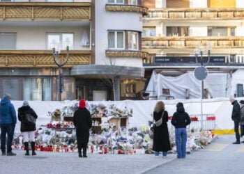 Πολίτες στέκονται μπροστά στον αυτοσχέδιο βωμό στο σημείο της τραγωδίας στο Κραν Μοντανά (φωτ.: EPA/Cyril Zingaro)