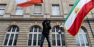 Διαδηλωτές κατά του καθεστώτος υψώνουν σημαίες του Ιράν στη διάρκεια διαδήλωσης στη Φρανκφούρτη (φωτ.: EPA/Matias Basualdo)