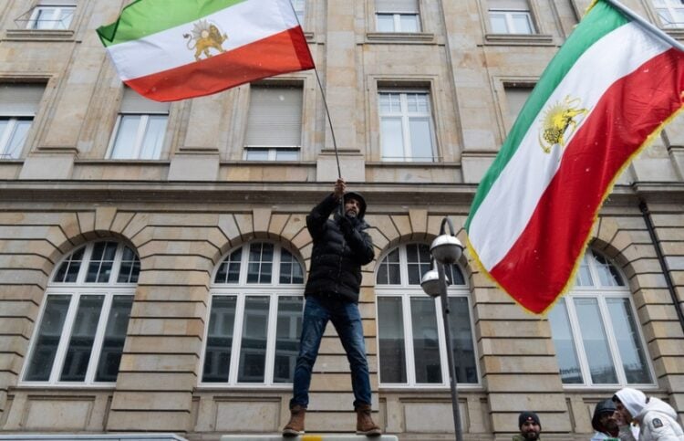 Διαδηλωτές κατά του καθεστώτος υψώνουν σημαίες του Ιράν στη διάρκεια διαδήλωσης στη Φρανκφούρτη (φωτ.: EPA/Matias Basualdo)