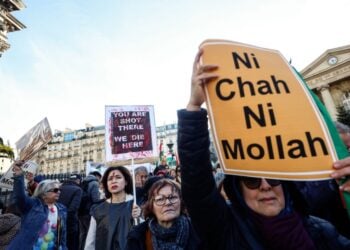 Διαδηλώτρια στο Παρίσι κρατά πανό που αναγράφει «Ούτε σάχης, ούτε μουλάς», στη διάρκεια διαμαρτυρίας για την κατάσταση στο Ιράν (φωτ.: EPA/Mohammed Badra)