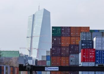 Το κτήριο της Ευρωπαϊκής Κεντρικής Τράπεζας διακρίνεται πίσω από κοντέινερ στο λιμάνι της Φρανκφούρτης. Η εμπορική συμφωνία μεταξύ ΕΕ και ΗΠΑ προέβλεπε την επιβολή δασμών ύψους 15% στις ευρωπαϊκές εξαγωγές προς τις ΗΠΑ αλλά την κατάργηση των δασμών σε ό,τι αφορά τις αμερικανικές εξαγωγές στην ΕΕ (φωτ.: EPA/Ronald Wittek)