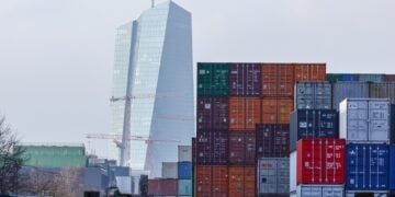 Το κτήριο της Ευρωπαϊκής Κεντρικής Τράπεζας διακρίνεται πίσω από κοντέινερ στο λιμάνι της Φρανκφούρτης. Η εμπορική συμφωνία μεταξύ ΕΕ και ΗΠΑ προέβλεπε την επιβολή δασμών ύψους 15% στις ευρωπαϊκές εξαγωγές προς τις ΗΠΑ αλλά την κατάργηση των δασμών σε ό,τι αφορά τις αμερικανικές εξαγωγές στην ΕΕ (φωτ.: EPA/Ronald Wittek)