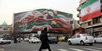 Ιρανή προσπερνά γιγαντοαφίσα που γράφει «Το Ιράν είναι η πατρίδα μας», στην Τεχεράνη (φωτ.: EPA/Abedin Taherkenareh)