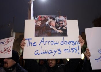 Ιρανοί φοιτητές κρατούν πανό στη διάρκεια διαμαρτυρίας μπροστά από τη βρετανική πρεσβεία στην Τεχεράνη. Στο κεντρικό πανό απεικονίζεται η απόπειρα δολοφονίας του Ντ. Τραμπ τον Ιούλιο του 2024 με τη φράση «Το βέλος δεν αστοχεί πάντα» (φωτ.: EPA/Abedin Taherkenareh)