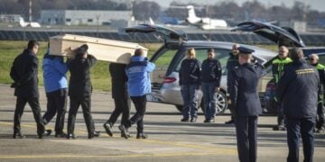 Ιταλοί αξιωματούχοι μεταφέρουν μια από τις σορούς στη διάρκεια επαναπατρισμού ενός από τα θύματα της φωτιάς στο Κραμ Μοντανά (φωτ.: EPA/Matteo Corner)