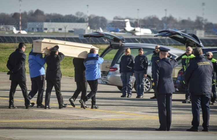 Ιταλοί αξιωματούχοι μεταφέρουν μια από τις σορούς στη διάρκεια επαναπατρισμού ενός από τα θύματα της φωτιάς στο Κραμ Μοντανά (φωτ.: EPA/Matteo Corner)