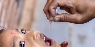 Ένας εργαζόμενος στον τομέα της υγείας χορηγεί εμβόλιο πολιομυελίτιδας σε παιδί σε χωριό του Νεπάλ, μετά από συνεργασία της κυβέρνησης της χώρας με τον Παγκόσμιο Οργανισμό Υγείας (φωτ.: EPA/Narendra Shrestha)