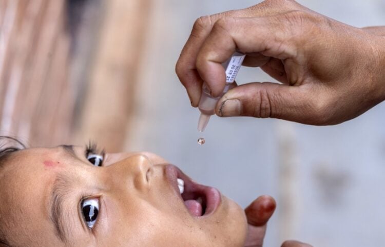 Ένας εργαζόμενος στον τομέα της υγείας χορηγεί εμβόλιο πολιομυελίτιδας σε παιδί σε χωριό του Νεπάλ, μετά από συνεργασία της κυβέρνησης της χώρας με τον Παγκόσμιο Οργανισμό Υγείας (φωτ.: EPA/Narendra Shrestha)