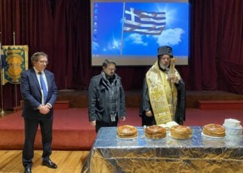 Δεξιά, ο επίσκοπος Ναζιανζού Αθηναγόρας προΐσταται της κοπής της βασιλόπιτας, με τη βοήθεια του πατέρα Ευαγόρα Κωνσταντινίδη και παρουσία του προέδρου της Παρέλασης για την Ελληνική Ανεξαρτησία της Νέας Υόρκης 2026, Λου Κάτσου (αριστερά) κατά τη συνάντηση της Ομοσπονδίας Ελληνικών Σωματείων της Μεγάλης Νέας Υόρκης (φωτ.: Εθνικός Κήρυκας/Ελένη Σακέλλη)