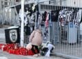 Γυναίκα αφήνει λίγα λουλούδια στη μνήμη των νεκρών οπαδών του ΠΑΟΚ, στην είσοδο του γηπέδου της Τούμπας (φωτ,: EUROKINISSI/Ραφαήλ Γεωργιάδης)