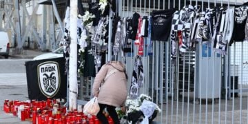Γυναίκα αφήνει λίγα λουλούδια στη μνήμη των νεκρών οπαδών του ΠΑΟΚ, στην είσοδο του γηπέδου της Τούμπας (φωτ,: EUROKINISSI/Ραφαήλ Γεωργιάδης)