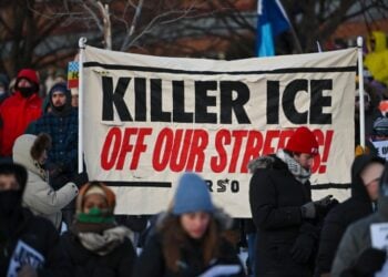 Πολίτες στη Μινεάπολη συμμετέχουν σε πορεία διαμαρτυρίας για την ανθρωποκτονία του 37χρονου νοσηλευτή, κρατώντας πανό που αναγράφει «Η δολοφόνος ICE έξω από τους δρόμους μας» (φωτ.: EPA/Craig Lassig)