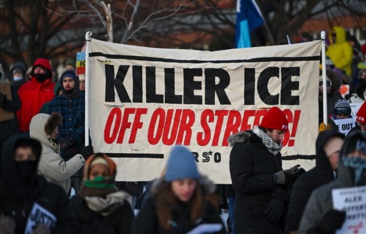 Πολίτες στη Μινεάπολη συμμετέχουν σε πορεία διαμαρτυρίας για την ανθρωποκτονία του 37χρονου νοσηλευτή, κρατώντας πανό που αναγράφει «Η δολοφόνος ICE έξω από τους δρόμους μας» (φωτ.: EPA/Craig Lassig)