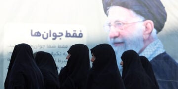 Ιρανές περνούν μπροστά από αφίσα του Αγιατολάχ Αλί Χαμενεΐ, κατά την άφιξή τους σε τελετή μνήμης για θύματα των αντικυβερνητικών διαδηλώσεων, στο τέμενος Μοσαλάχ της Τεχεράνης. 17 Φεβρουαρίου 2026 (φωτ.: EPA / Abedin Taherkenareh)