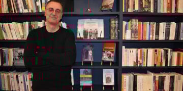 Ο Μενέλαος Χαραλαμπίδης στο βιβλιοπωλείο Penny Lane στη Νέα Σμύρνη, ποζάρει μπροστά από το βιβλίο του «Οι δωσίλογοι» (φωτ.: Γεωργία Βορύλλα)