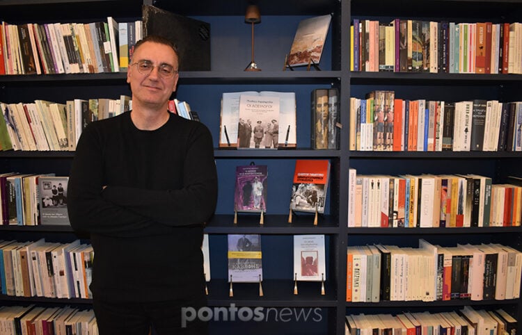 Ο Μενέλαος Χαραλαμπίδης στο βιβλιοπωλείο Penny Lane στη Νέα Σμύρνη, ποζάρει μπροστά από το βιβλίο του «Οι δωσίλογοι» (φωτ.: Γεωργία Βορύλλα)