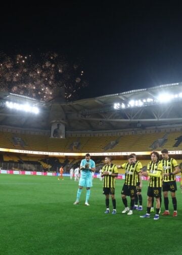 Παίκτες της ΑΕΚ στο γήπεδο, ενώ στον εξωτερικό χώρο ανάβουν πυροτεχνήματα (φωτ.: EUROKINISSI/Μάρκος Χουζούρης)