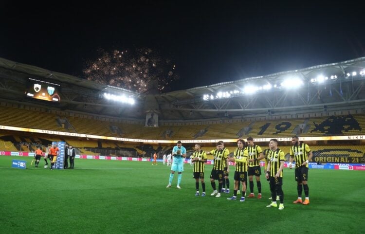 Παίκτες της ΑΕΚ στο γήπεδο, ενώ στον εξωτερικό χώρο ανάβουν πυροτεχνήματα (φωτ.: EUROKINISSI/Μάρκος Χουζούρης)