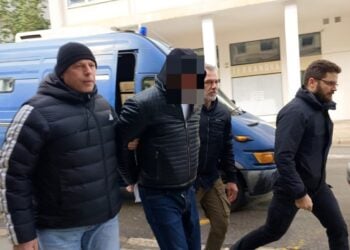 Αστυνομικοί συνοδεύουν τον κρατούμενο αρχιφύλακα στον εισαγγελέα (φωτ.: ΑΠΕ-ΜΠΕ/Άρης Μαρτάκος)