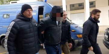 Αστυνομικοί συνοδεύουν τον κρατούμενο αρχιφύλακα στον εισαγγελέα (φωτ.: ΑΠΕ-ΜΠΕ/Άρης Μαρτάκος)