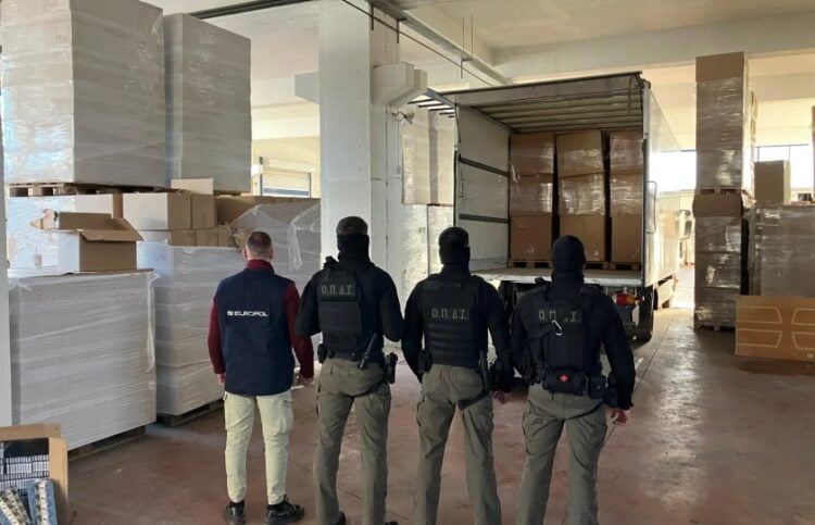 Αστυνομικοί στέκονται μπροστά σε φορτηγό με κούτες γεμάτες από λαθραία τσιγάρα (φωτ.: Ελληνική Αστυνομία)