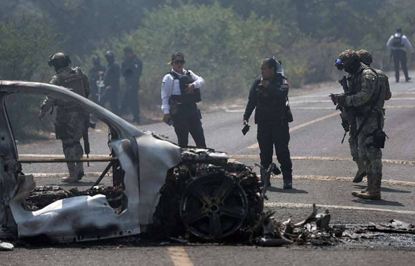 Αστυνομικοί της Μορέλια και στρατιωτικοί επιχειρούν στο σημείο όπου όχημα πυρπολήθηκε μετά τη δολοφονία του Νεμέσιο Οσεγκέρα Θερβάντες («Ελ Μέντσο»), ηγέτη του Καρτέλ Χαλίσκο Νέα Γενιά, 22 Φεβρουαρίου 2026 (φωτ.: EPA / Ivan Villanueva)