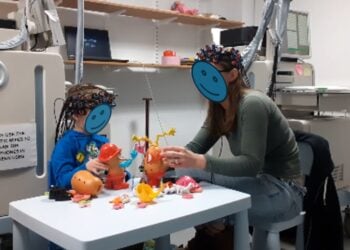 Χαρακτηριστικό στιγμιότυπο από την έρευνα, στο οποίο μητέρα και παιδί παίζουν φορώντας ειδικά ηλεκτρόδια που καταγράφουν την εγκεφαλική λειτουργία τους (φωτ.: Frontiers in Cognition)