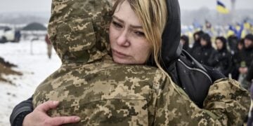 Συγγενείς και στρατιώτες αγκαλιάζονται στη διάρκεια επιμνημόσυνης δέησης στο Χάρκοβο για τους πεσόντες στον πόλεμο (φωτ.: EPA/Sergey Kozlov)