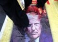 Ιρανοί πατούν πάνω σε αφίσα του Ντόναλντ Τραμπ στη διάρκεια συγκέντρωσης στην Τεχεράνη (φωτ.: EPA/Abedin Taherkenareh)