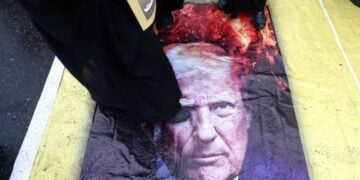 Ιρανοί πατούν πάνω σε αφίσα του Ντόναλντ Τραμπ στη διάρκεια συγκέντρωσης στην Τεχεράνη (φωτ.: EPA/Abedin Taherkenareh)