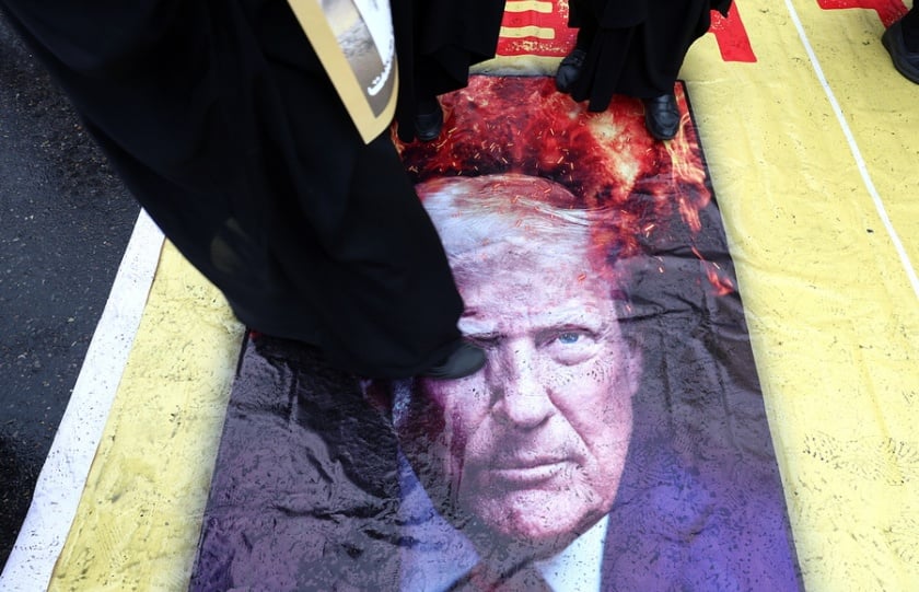 Ιρανοί πατούν πάνω σε αφίσα του Ντόναλντ Τραμπ στη διάρκεια συγκέντρωσης στην Τεχεράνη (φωτ.: EPA/Abedin Taherkenareh)