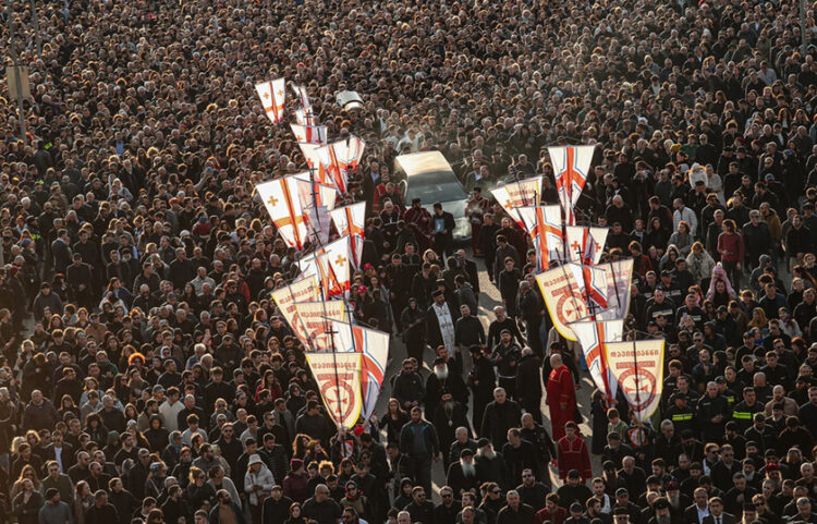 Νεκροφόρα που μεταφέρει το φέρετρο του Πατριάρχη Γεωργίας Ηλία Β' διασχίζει πλήθος πιστών έξω από τον καθεδρικό ναό της Αγίας Τριάδας στην Τιφλίδα. 18 Μαρτίου 2026 (φωτ.: EPA / David Mdzinarishvili)