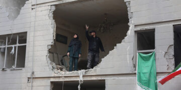 Ιρανοί σε κατεστραμμένη από αεροπορικά πλήγματα πολυκατοικία στη νότια Τεχεράνη. 15 Μαρτίου 2026 (φωτ.: EPA / Abedin Taherkenareh)