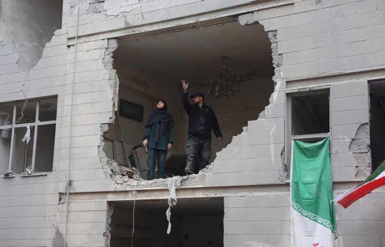 Ιρανοί σε κατεστραμμένη από αεροπορικά πλήγματα πολυκατοικία στη νότια Τεχεράνη. 15 Μαρτίου 2026 (φωτ.: EPA / Abedin Taherkenareh)