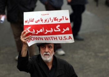 Ιράνος κρατά πανό που γράφει «Κάτω οι ΗΠΑ» στη διάρκεια κηδείας αξιωματούχου του καθεστώτος στην Τεχεράνη (φωτ.: EPA/Abedin Taherkenareh)