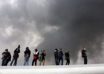 Μέλη τηλεοπτικών συνεργείων και φωτορεπόρτερ καταγράφουν ισραηλινό πλήγμα σε διυλιστήριο στα περίχωρα της Τεχεράνης (φωτ.: EPA/Abedin Taherkenareh)