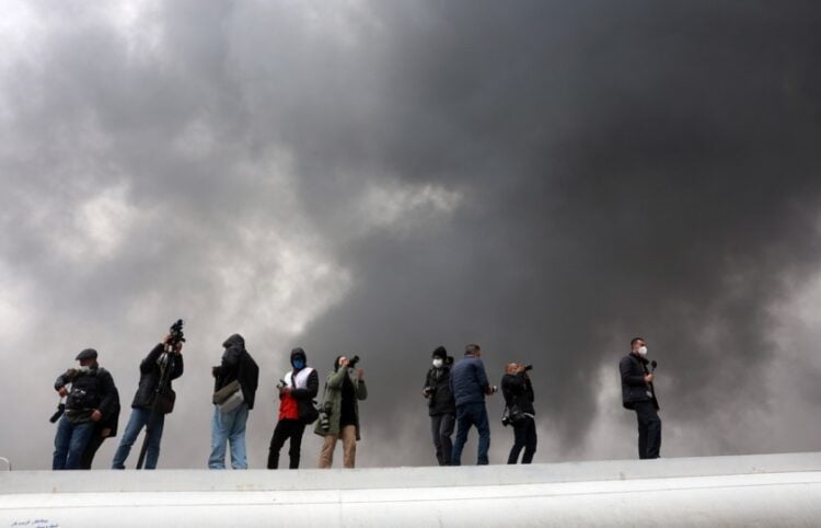 Μέλη τηλεοπτικών συνεργείων και φωτορεπόρτερ καταγράφουν ισραηλινό πλήγμα σε διυλιστήριο στα περίχωρα της Τεχεράνης (φωτ.: EPA/Abedin Taherkenareh)