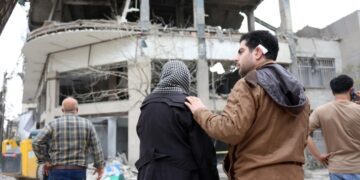 Ιρανοί κοιτούν κατεστραμμένο κτήριο κατοικιών στην Τεχεράνη, μετά από ισραηλινοαμερικανικό πλήγμα (φωτ.: EPA/Abedin Taherkenareh)