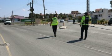 Αστυνομικοί ελέγχουν την κυκλοφορία σε κοινότητα της Κύπρου μετά την εφαρμογή κατ' οίκον περιορισμού (φωτ.: philenews.com)