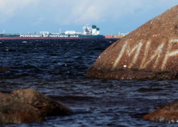 Πετρελαιοφόρο της ρωσικής εταιρείας Sovcomflot στη Βαλτική, στην περιφέρεια του Λένινγκραντ. Πίσω από βράχο με γκράφιτι η λέξη «Ειρήνη» στα ρωσικά (φωτ.: EPA / Maxim Shipenkov)