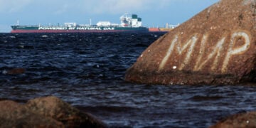 Πετρελαιοφόρο της ρωσικής εταιρείας Sovcomflot στη Βαλτική, στην περιφέρεια του Λένινγκραντ. Πίσω από βράχο με γκράφιτι η λέξη «Ειρήνη» στα ρωσικά (φωτ.: EPA / Maxim Shipenkov)