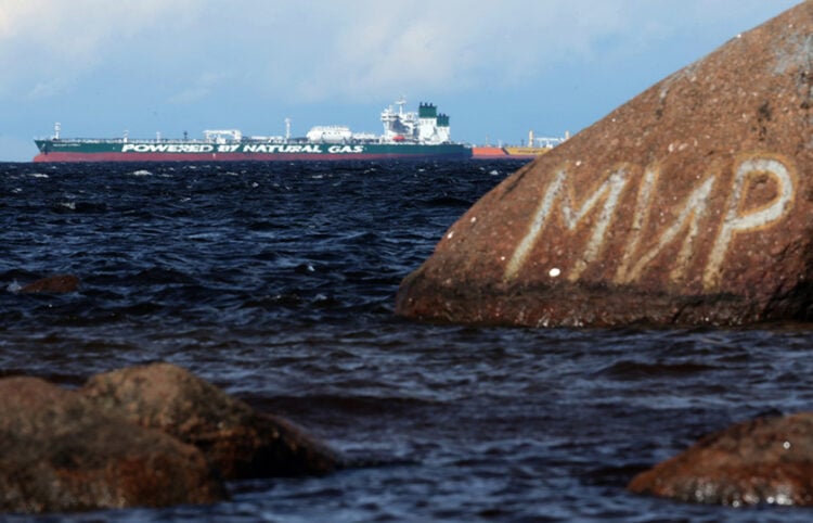 Πετρελαιοφόρο της ρωσικής εταιρείας Sovcomflot στη Βαλτική, στην περιφέρεια του Λένινγκραντ. Πίσω από βράχο με γκράφιτι η λέξη «Ειρήνη» στα ρωσικά (φωτ.: EPA / Maxim Shipenkov)