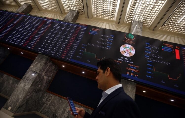 Χρηματιστής κοιτά τις τιμές των μετοχών που πέφτουν στο Καράτσι του Πακιστάν, λόγω του πολέμου στη Μέση Ανατολή (φωτ.: EPA/Rehan Khan)