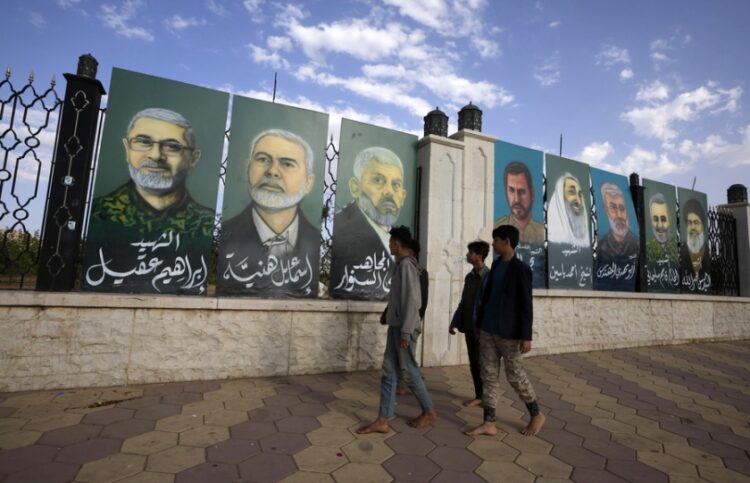 Πεζοί προσπερνούν ταμπλό που απεικονίζουν νεκρούς στρατιωτικούς και πολιτικούς αξιωματούχους σιιτικών ομάδων που υποστηρίζονται από το Ιράν στην Υεμένη, τον Λίβανο, το Ιράκ και την Παλαιστίνη, σε δρόμο της Σανάα(φωτ.: EPA/Yahya Arhab)