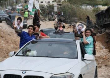 Εκτοπισμένοι πανηγυρίζουν μέσα στα οχήματά τους καθώς περιμένουν στην ουρά στη γέφυρα Κασμίγια, επιστρέφοντας στα σπίτια τους κατά μήκος της ακτής κοντά στην Τύρο, σήμερα, στο νότιο Λίβανο (φωτ.: EPA/WAEL HAMZEH)